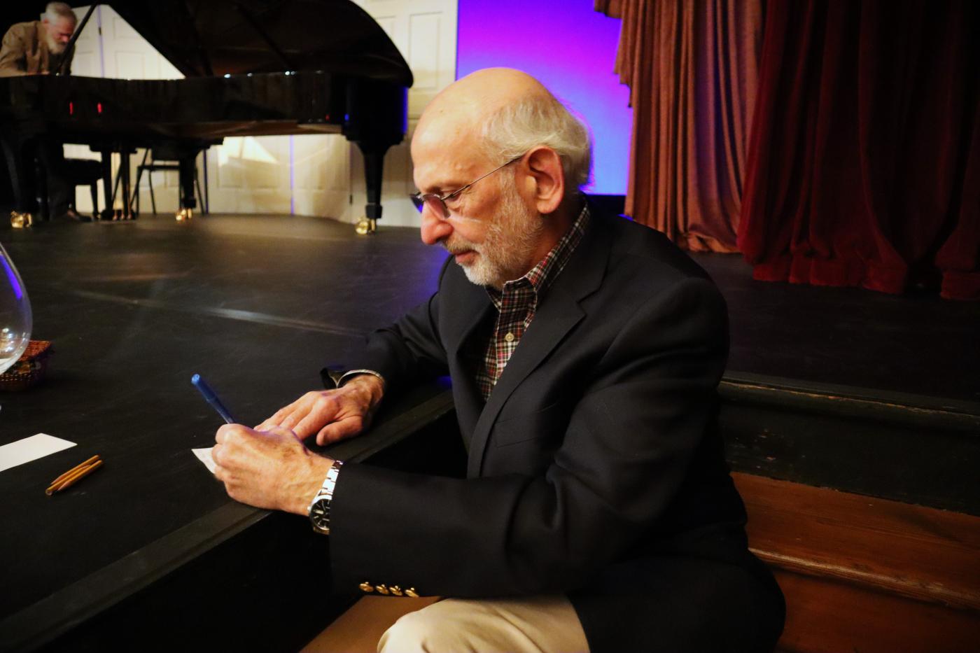 An audience member writing in questions during intermission